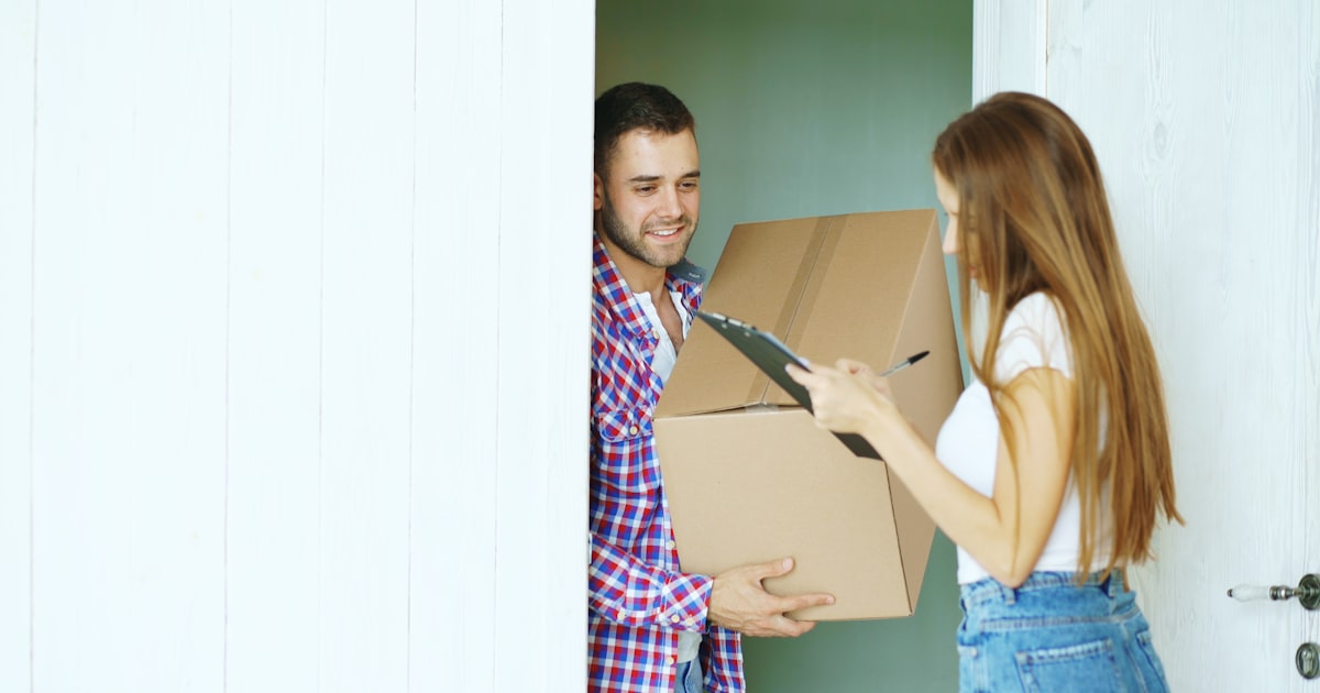 Person signing for a parcel delivery at the door